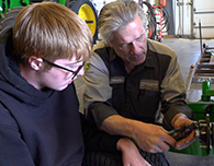  Christopher Maybach teaches Hayden Pickrel how to assemble a rotary mower
